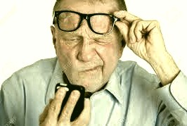  man lifting his glasses to squint at his phone  
